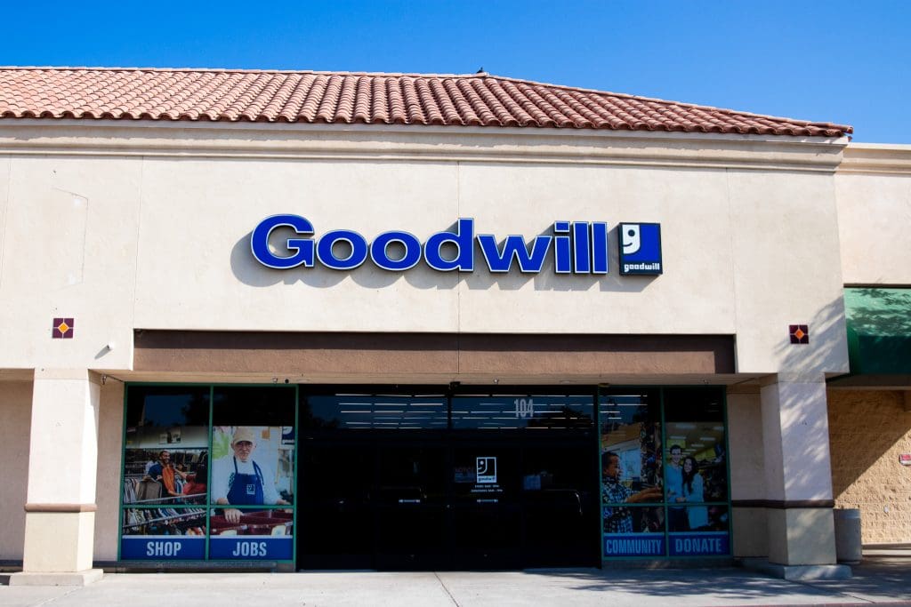 Goodwill Hanford Location. The front entrance of the store with large blue signage and wall photos promoting shopping, jobs, community, and donations.